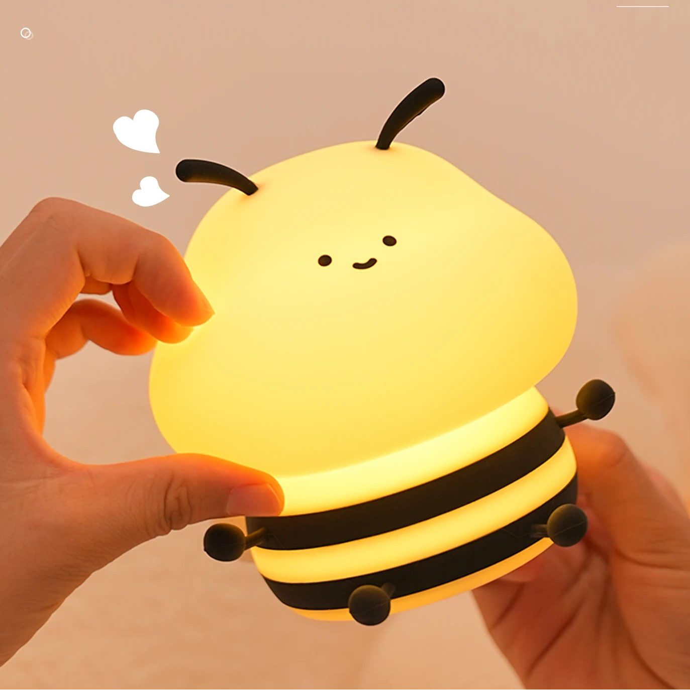 Cute bee-shaped kawaii night light held by a hand with text about safe silicone material.