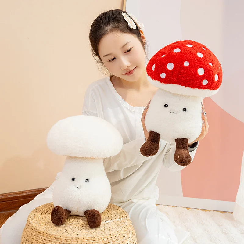 Woman holding two kawaii plush mushroom toys against a plain background