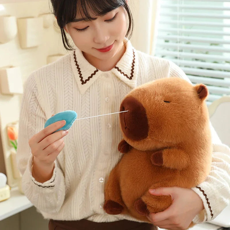 Person holding a kawaii plush toy and a blue device in a room with light-colored walls.