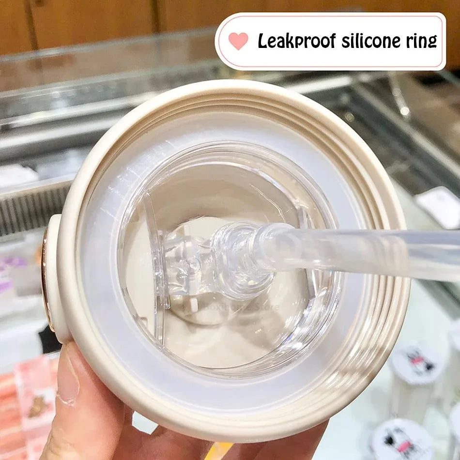 Leakproof silicone ring on a kawaii tumbler with straw held by a hand.
