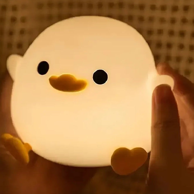 Cute duck-shaped kawaii night light held by a person with a warm glow.
