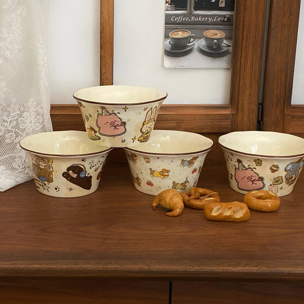 Set of four ceramic kawaii ramen bowls with cartoon designs on a wooden surface.