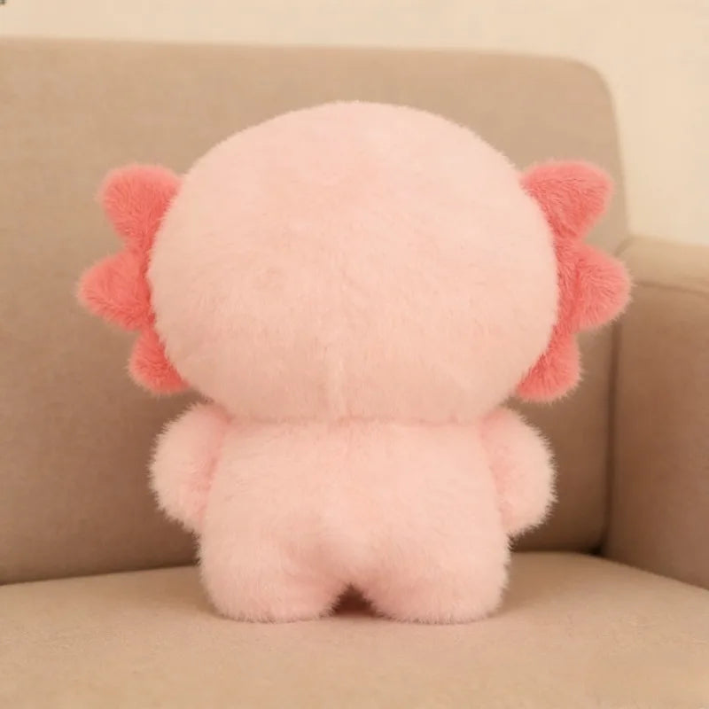 Pink kawaii plush toy with red accents on a beige couch