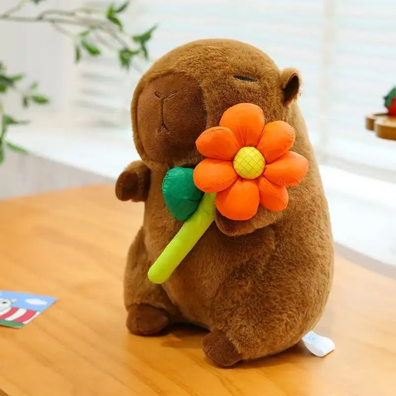 Brown kawaii plush toy holding an orange flower on a wooden surface with a blurred background