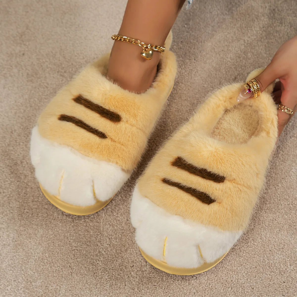 Pair of fluffy slippers with cat paw design on a neutral background
