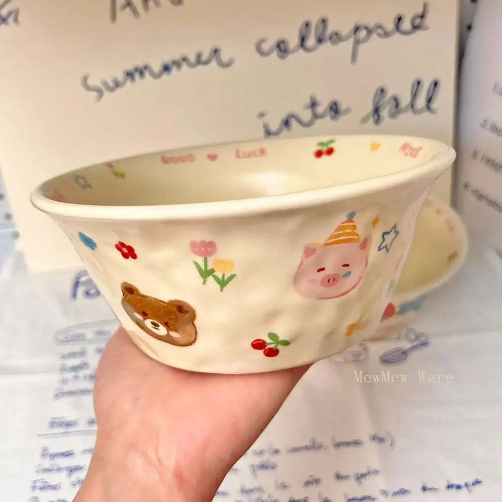 Ceramic kawaii ramen bowl with cartoon designs held in front of a book