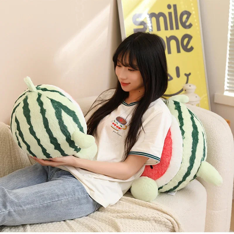 Person sitting on a couch holding a large kawaii plush watermelon toy with a 'Smile' poster in the background.