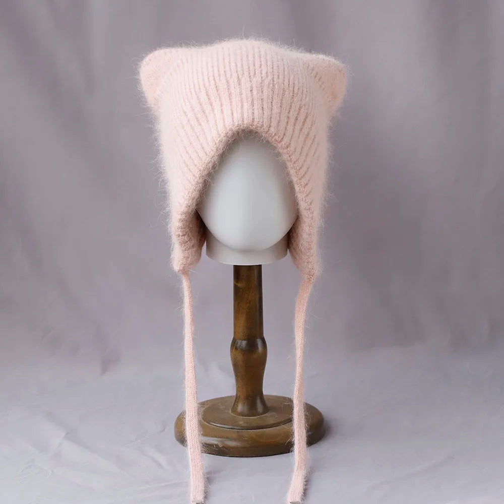 Knitted pink cat ear Kawaii hat on a mannequin head against a gray background
