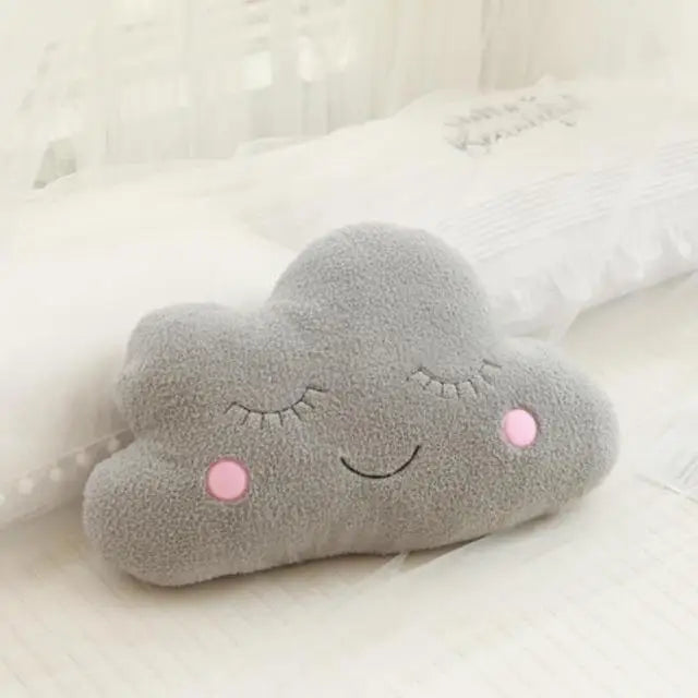 Gray cloud-shaped kawaii pillow with a smiley face on a white background