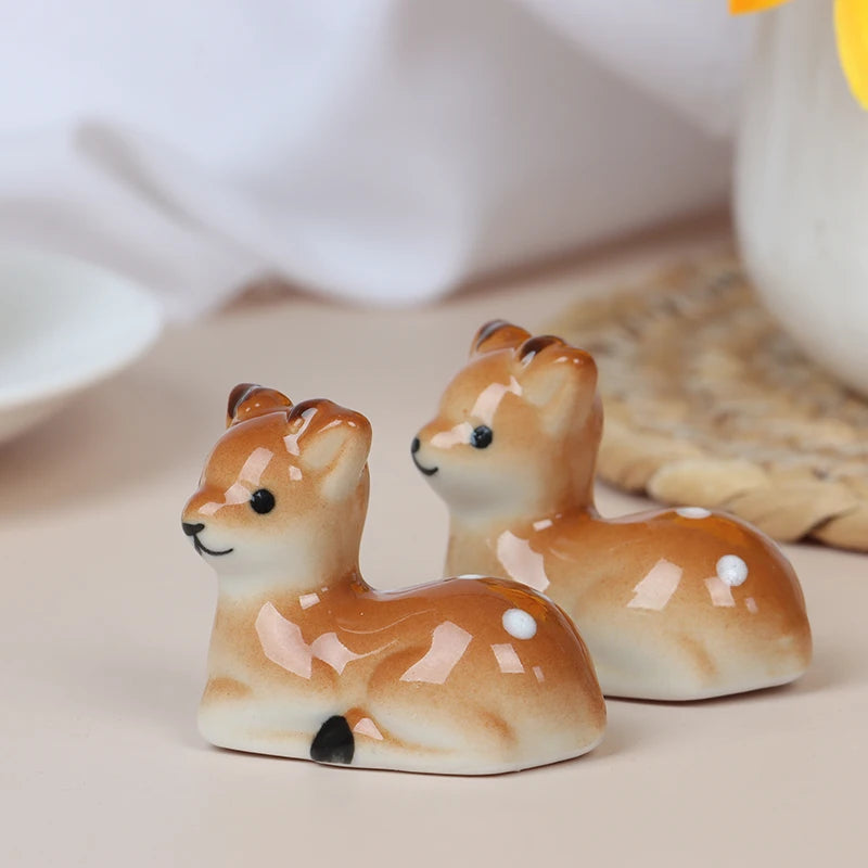 Two ceramic deer kawaii chopstick holders on a neutral background