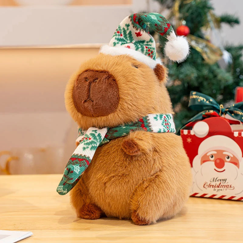 Kawaii plush bear toy with Christmas hat and scarf in front of a decorated Christmas tree.