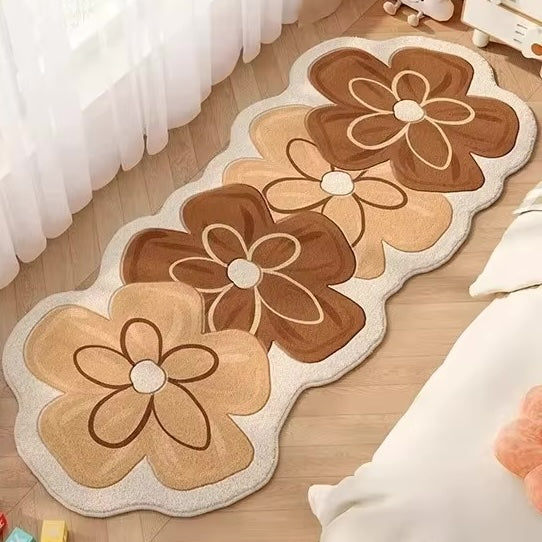 A rug with four flowers in brown on a wooden floor.