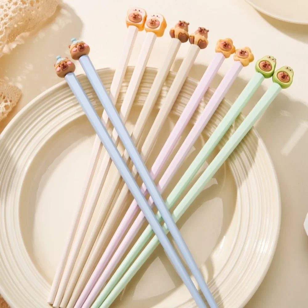 Set of colorful kawaii chopsticks with cute animal-shaped tips on a white plate