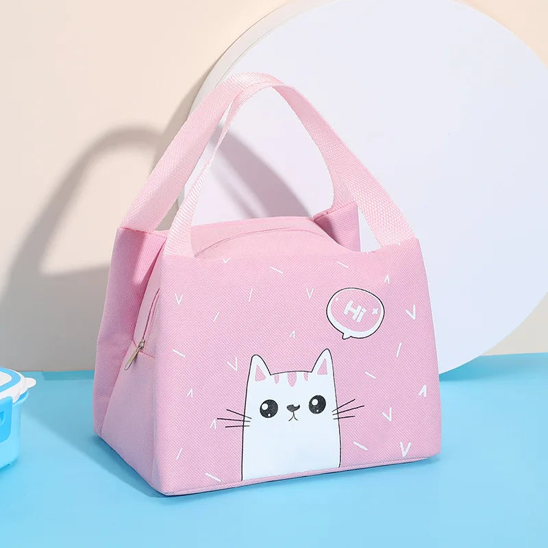 Pink kawaii lunch bag with a cat design on a blue surface