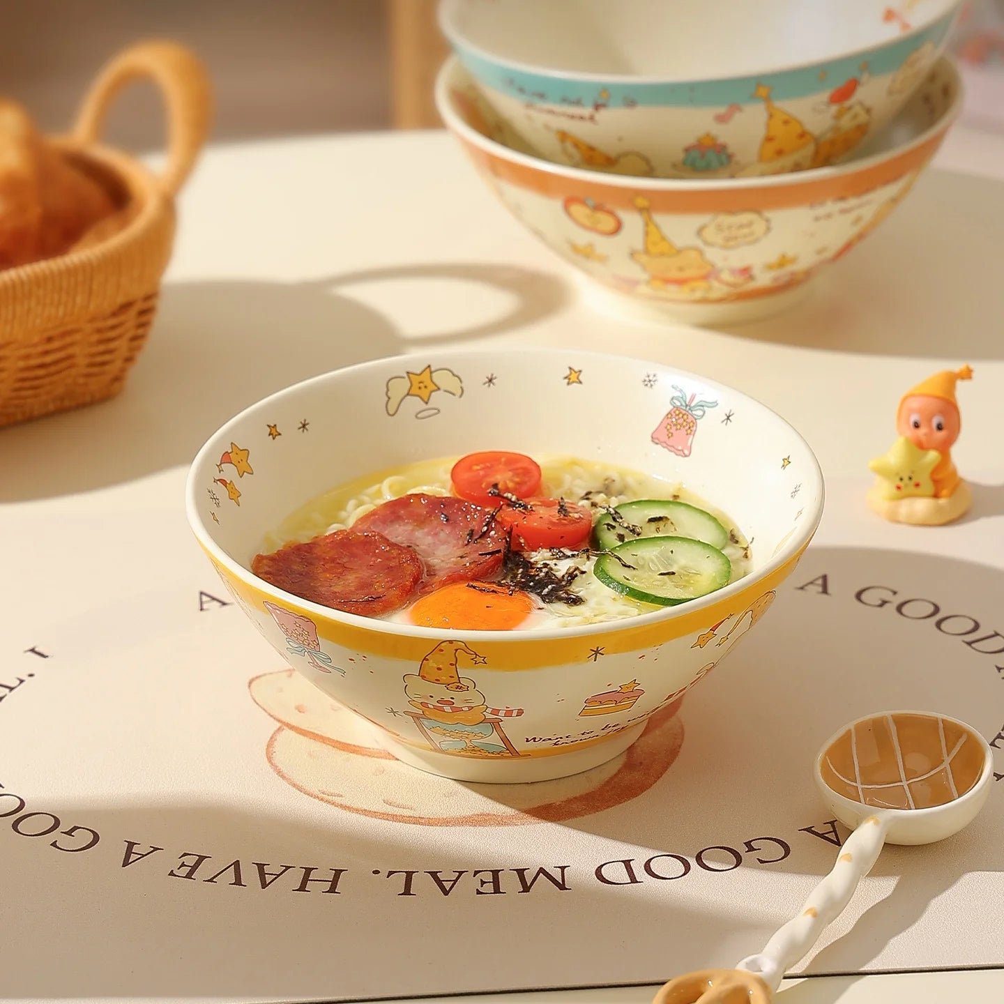 Children's kawaii ramen bowl with a meal and cartoon characters on a table with a paper background.
