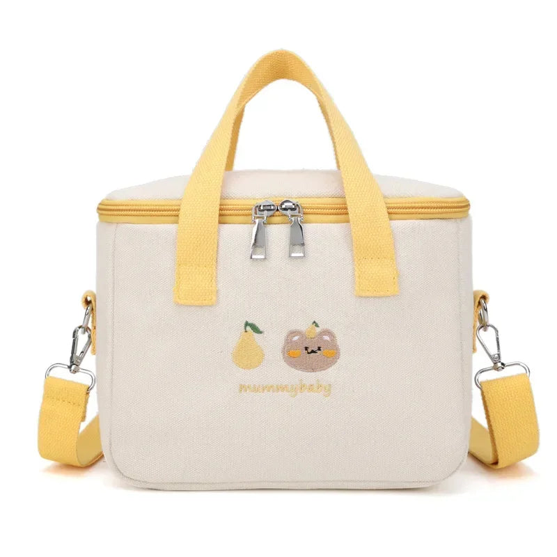 Beige kawaii lunch bag with yellow handles and accents, featuring cartoon cat and pear designs, on a white background.