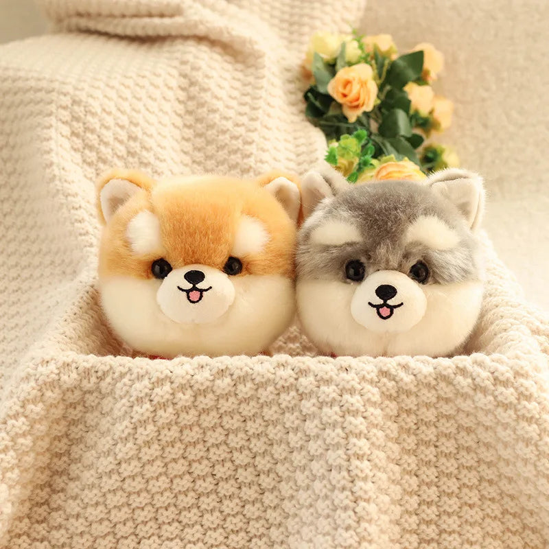 Two kawaii plush toys resembling dogs on a textured surface with flowers in the background