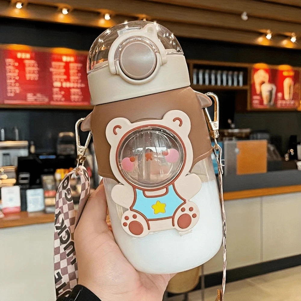 Cartoon character kawaii water bottle held in a hand with a blurred cafe background