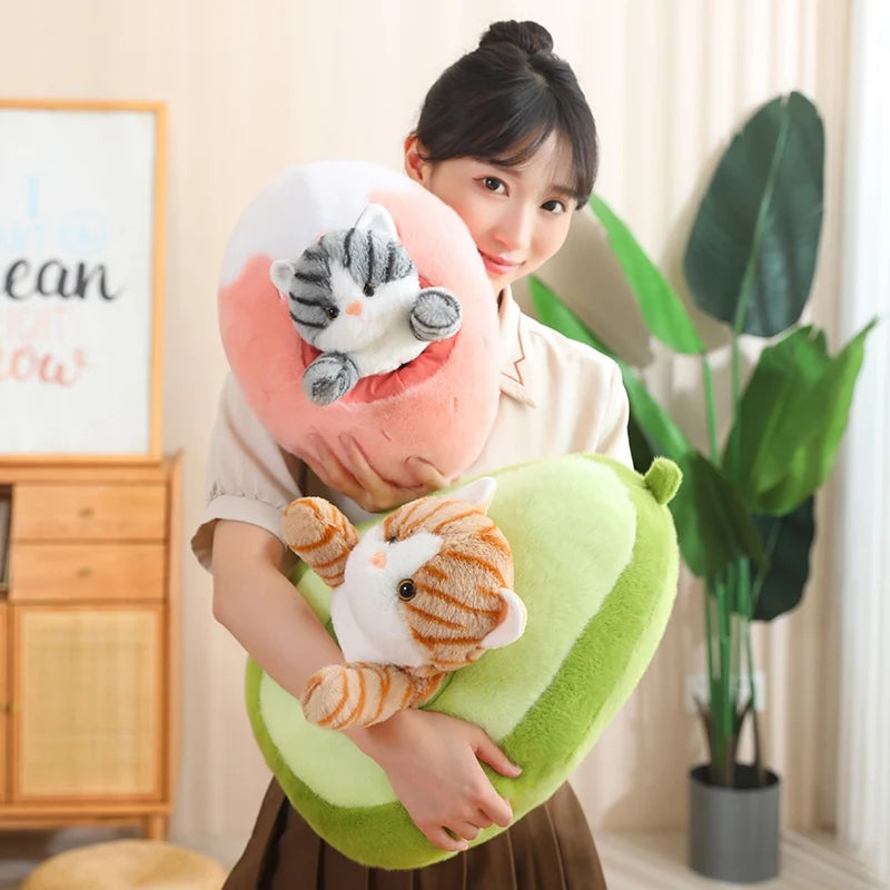 Woman holding a heart-shaped kawaii pillow with cat designs in a room with a plant and wooden cabinet.