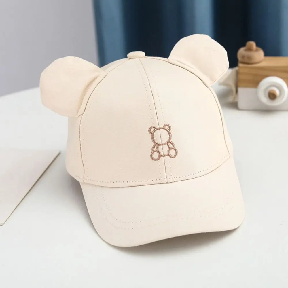 Beige cap with Kawaii bear ears and embroidered bear design on a light surface.
