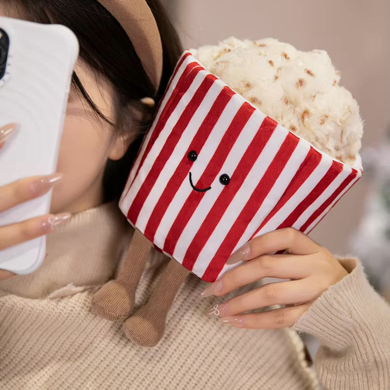 Person holding a kawaii plush toy with a red and white striped hat and a smiley face.
