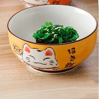 Ceramic kawaii bowl with a cartoon cat design on a wooden surface