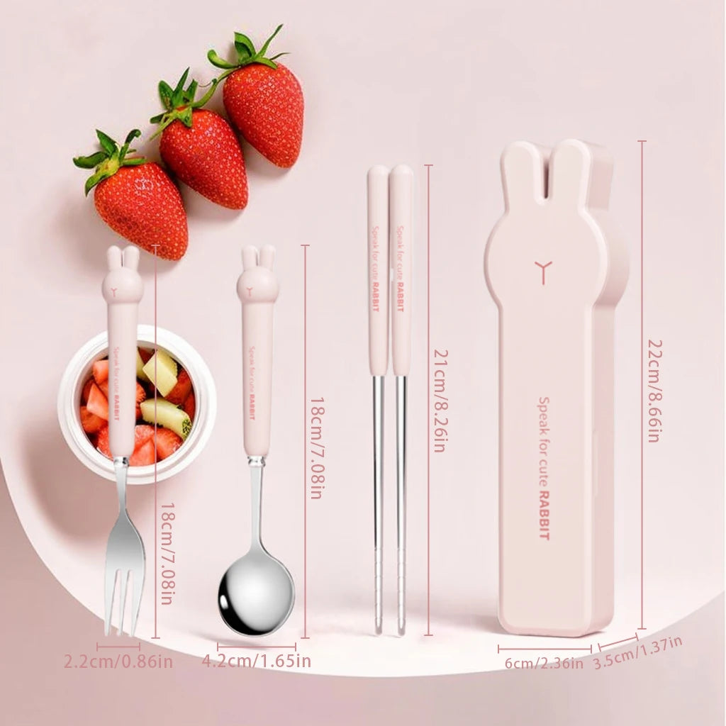 Children's kawaii utensils set with fork, spoon, and chopsticks in a pink case, accompanied by strawberries and a bowl of fruit salad on a pink background.