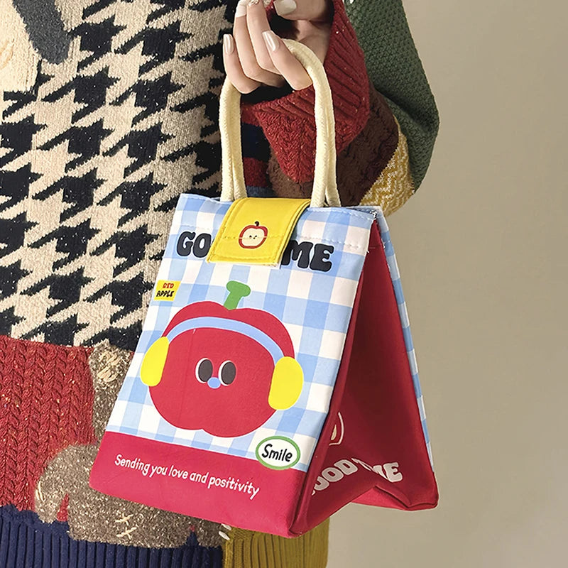Colorful kawaii tote bag with cartoon design held by a person wearing a patterned coat.