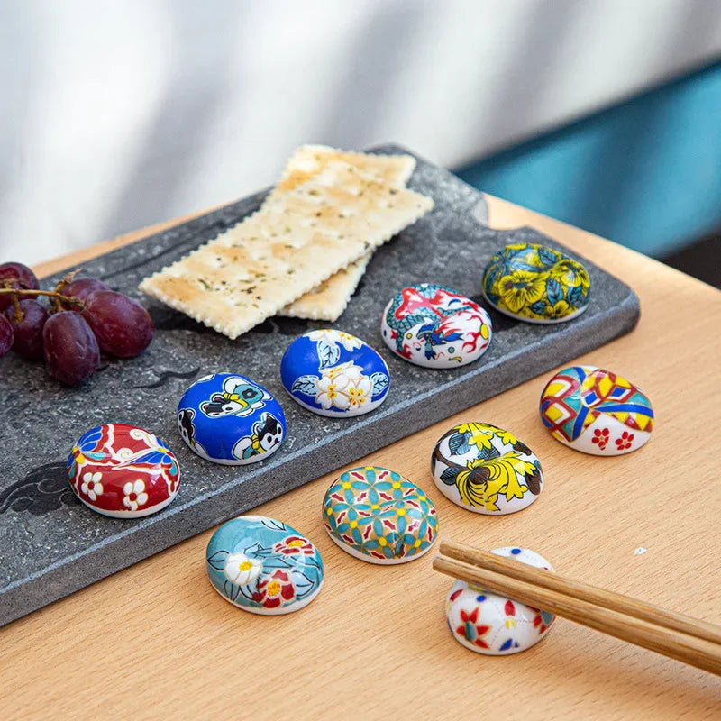 A set of ten multicolored kawaii chopstick holders sitting on a table