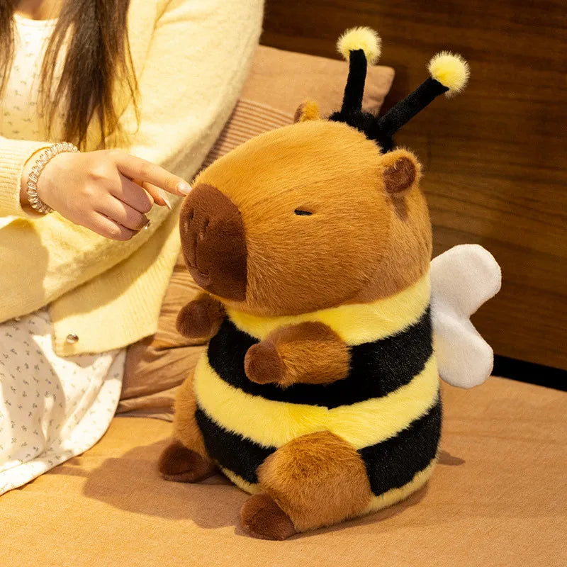 Kawaii plush toy bee held by a person on a wooden surface