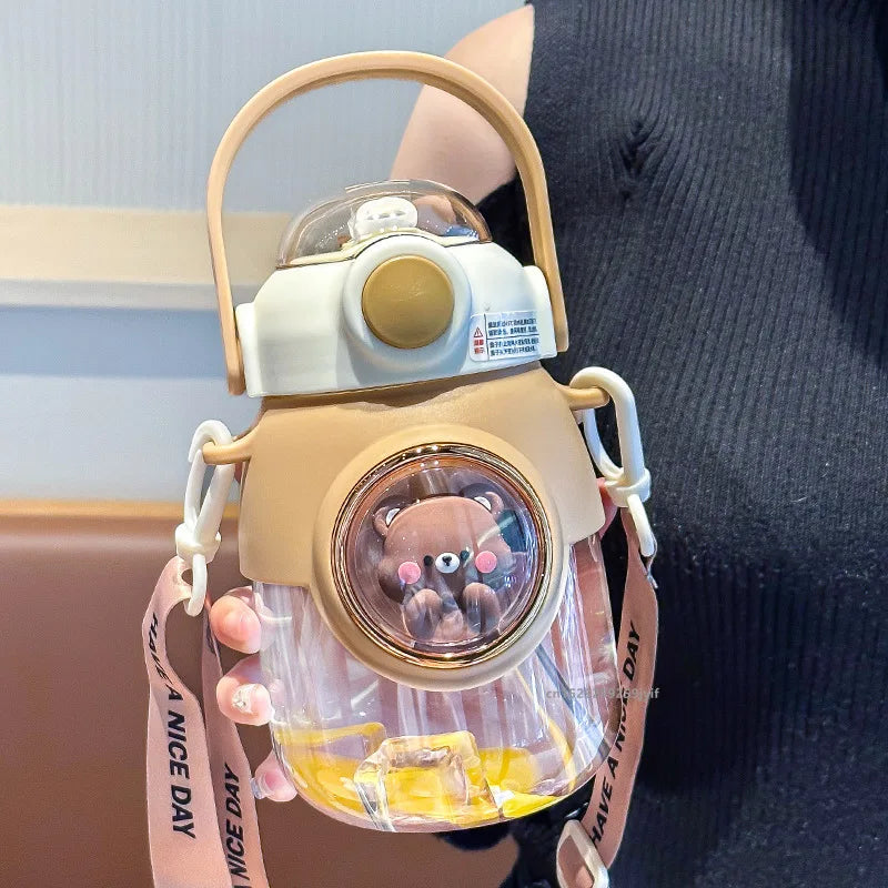 Clear kawaii water bottle with bear design and beige lid held by a person