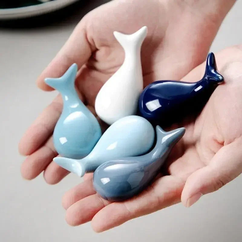 Five whale shaped kawaii chopstick holders being held by a person