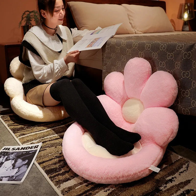 Person sitting on a pink flower-shaped kawaii cushion reading a magazine in a bedroom.
