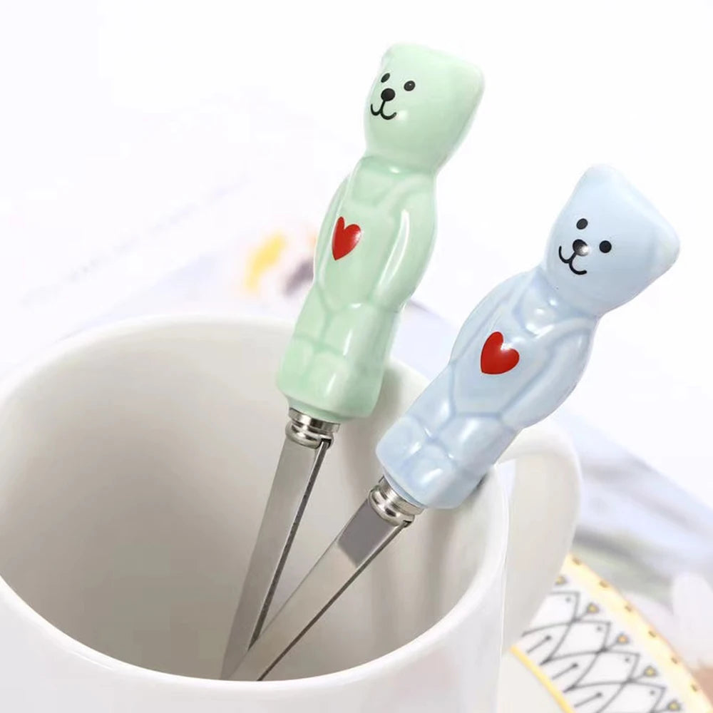 Two cartoon bear-shaped kawaii utensils with red hearts on a white background