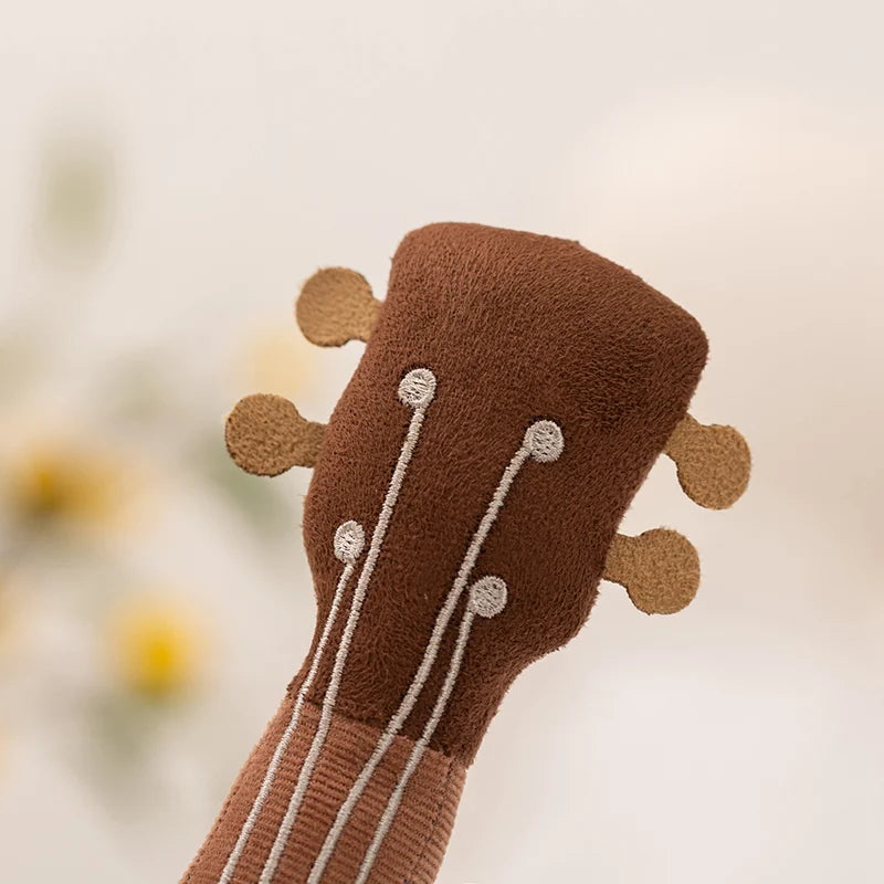 Close-up of a brown kawaii plush toy resembling a guitar on a blurred background