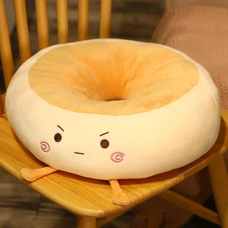 Plush donut-shaped kawaii pillow with a face on a wooden chair