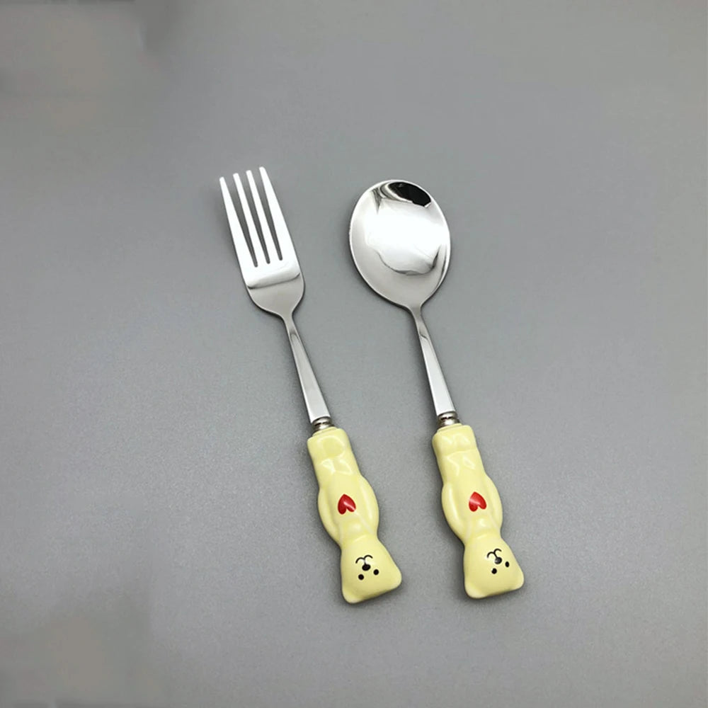 Yellow, bear shaped kawaii utensils on a gray backround