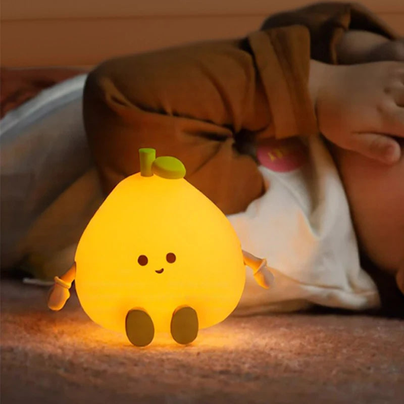 Yellow cartoon-style kawaii night light on a bed with a child in the background