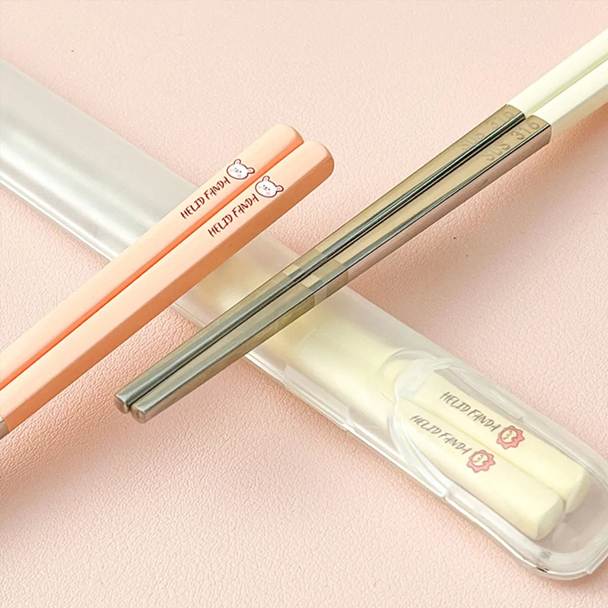 Metallic kawaii chopsticks and clear case on a pink background