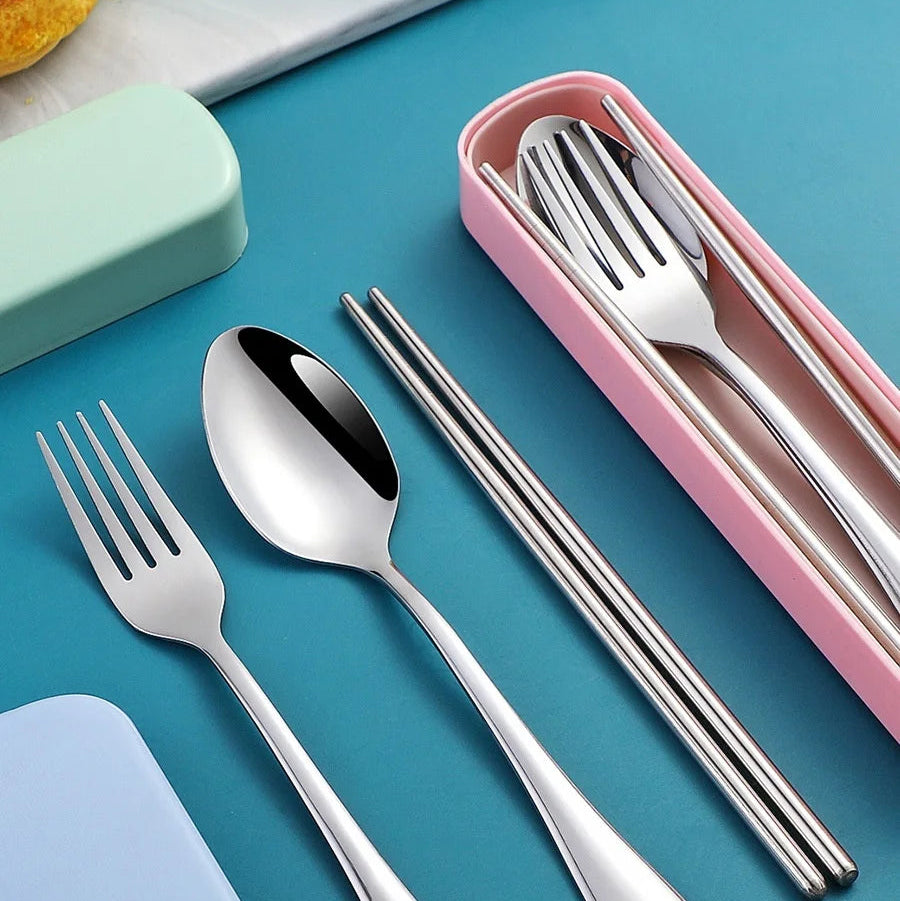 Set of stainless steel kawaii utensils including fork, spoon, and chopsticks in a pink case on a blue background.