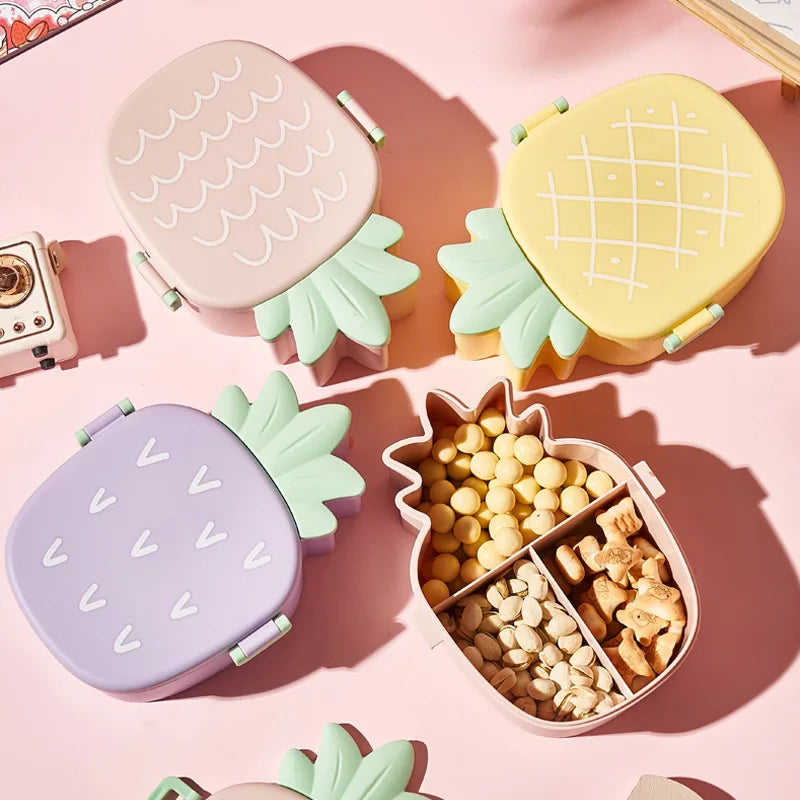 Set of pineapple-shaped kawaii bento boxes on a pink background