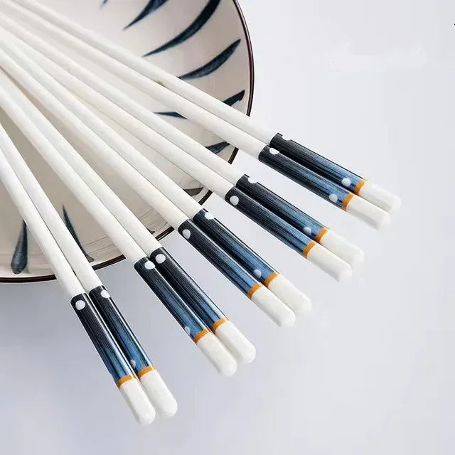 Set of blue and white kawaii chopsticks on a light gray background