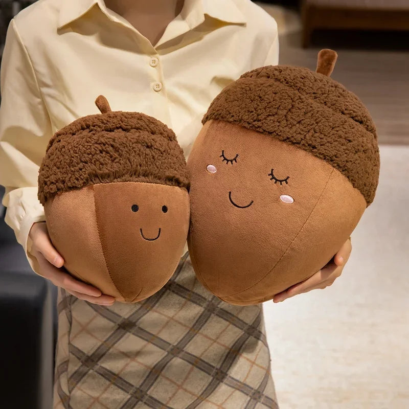 Person holding two kawaii plush acorn-shaped toys with faces.