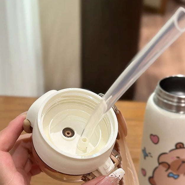 Close-up of a white lid with a straw being inverted, held by a hand, with a background of a kawaii-themed tumbler.