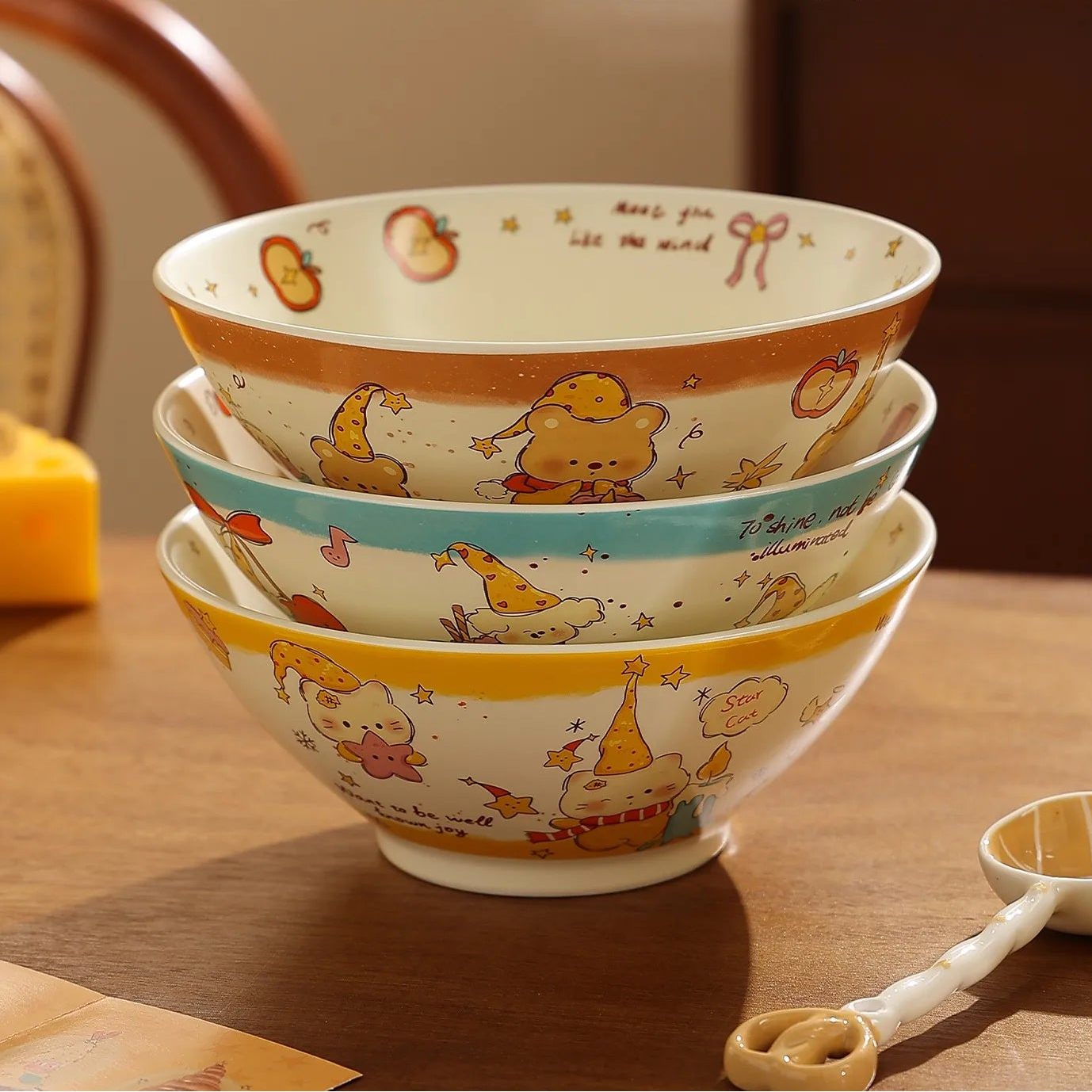 Stack of ceramic kawaii ramen bowls with cartoon designs on a wooden table