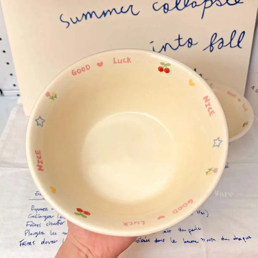 Small beige kawaii ramen bowl with text and graphics held over a notebook with writing.