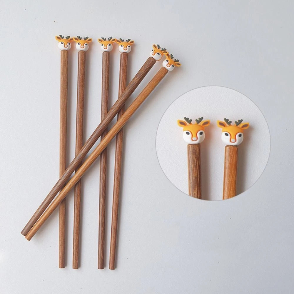 Wooden kawaii chopsticks with deer heads on a light gray background