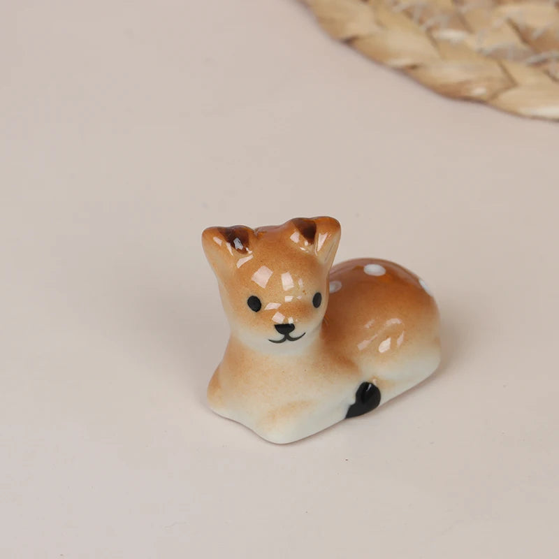Small ceramic deer kawaii chopstick holders on a beige surface