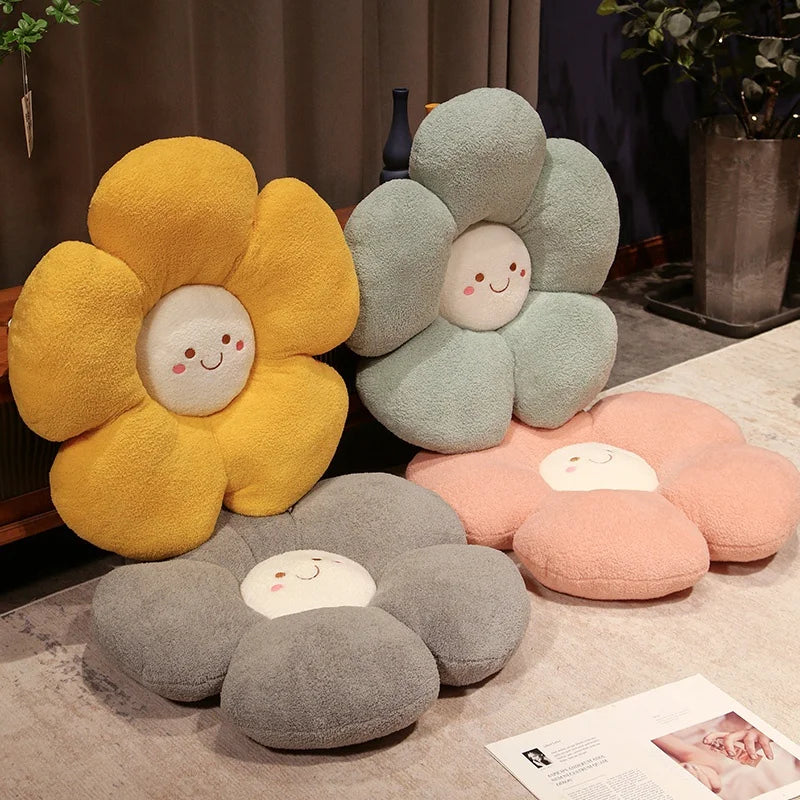 Flower-shaped kawaii cushions in yellow, gray, and pink on a carpeted floor.