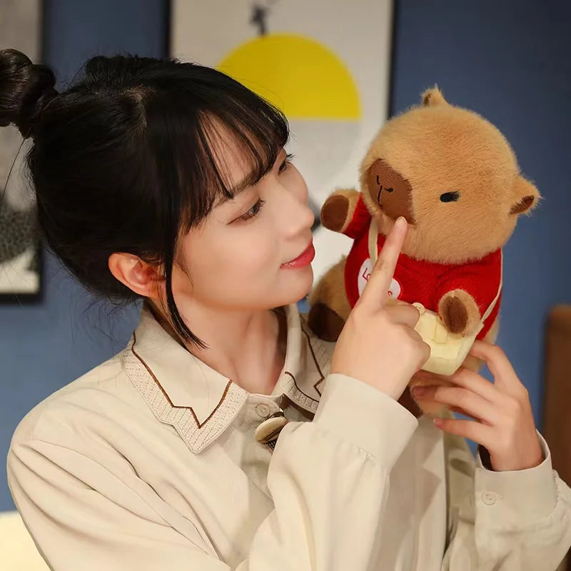 Woman holding a kawaii plush bear toy in a room with a blue wall and framed picture.